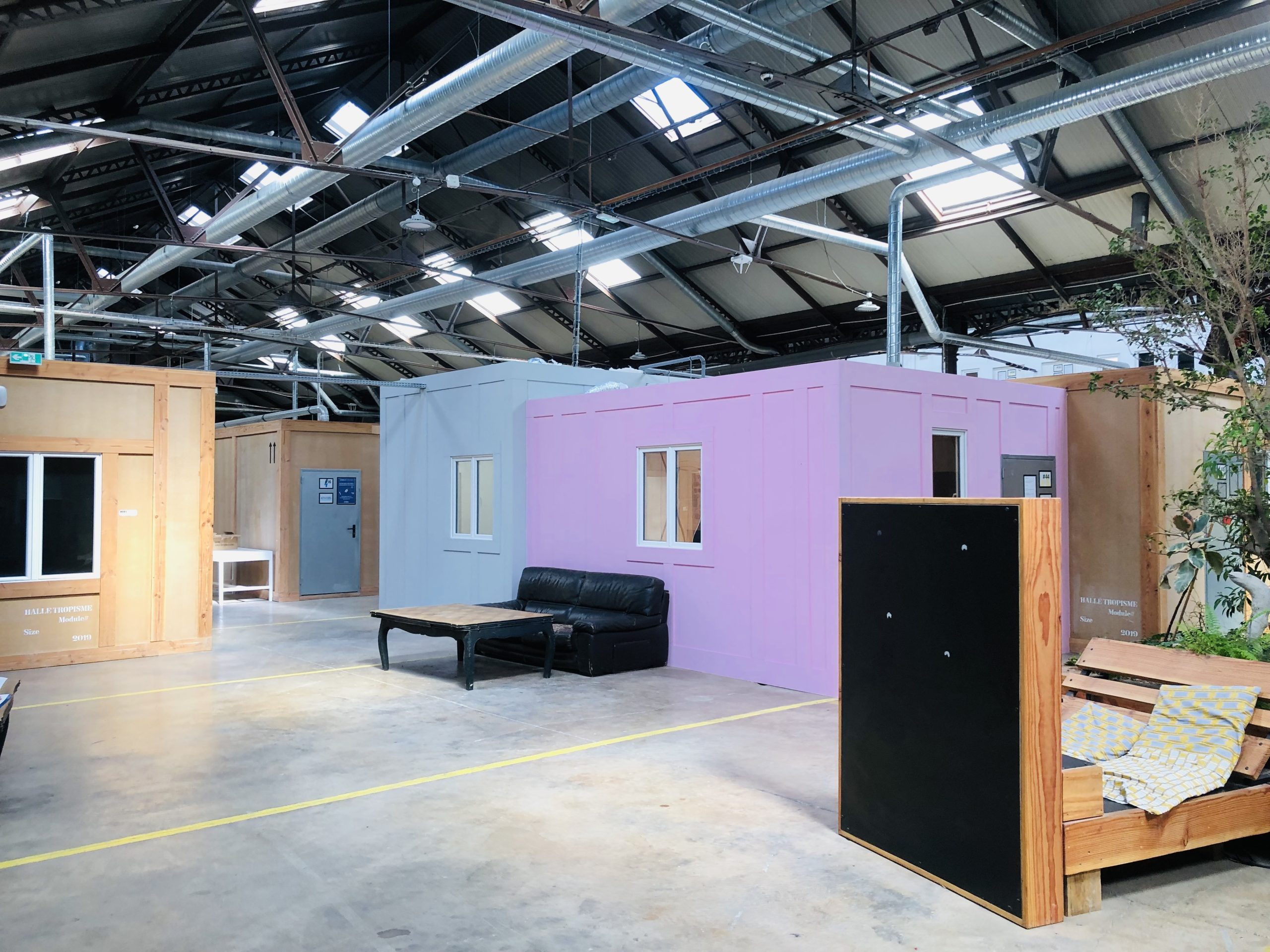 Das Bild zeigt das innere der Halle Tropisme, in dem Bunte Arbeitscontainer aus Holz stehen (Bild: Leading Edge).